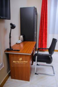 MbaleMbale Rosewood Hotel的电视机前的桌子和椅子