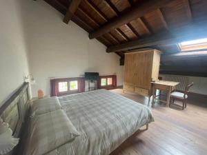 Monticello Conte OttoAlbaspina BioAgriturismo的一间卧室配有一张大床和一张书桌