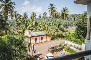 CorgaoDhanashree Riverview Hotel的棕榈树房屋的阳台享有风景。