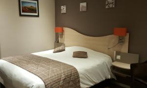 兰斯Logis Hotel au tambour的一间卧室设有一张大床和一个水槽