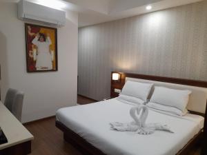 普塔帕蒂Sai Maa Hotel & Residency的一间卧室配有一张带白色毛巾的床