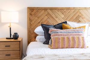 Port AdelaideJewel on Jubilee - New 1 Bed Apt with Parking的一间卧室配有一张带木制床头板和枕头的床。