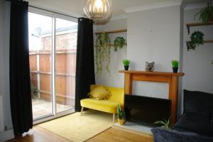 诺里奇Lovely 3 bedroom house with free parking & garden的客厅设有黄色椅子和壁炉