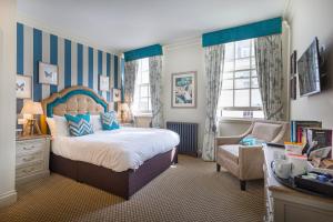 拉姆西The White Horse Hotel, Romsey, Hampshire的一间卧室配有一张床、一把椅子和窗户。