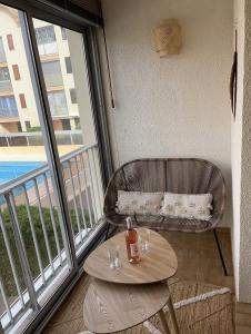 格吕桑Appartement T2 Gruissan port, rive gauche的阳台配有桌子、椅子和窗户。