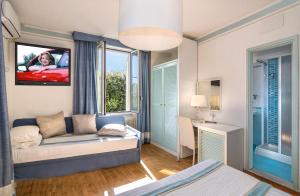 马尔米堡Raffaelli Villino Limoni的一间卧室配有一张床,并在一间客房内配有电视。