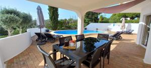 卡武埃鲁Casa Gemeas的一个带桌椅的庭院和一个游泳池