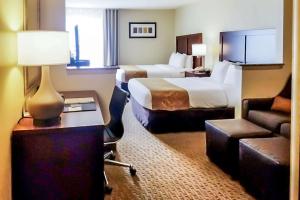 欧文Quality Suites Las Colinas Center的酒店客房设有一间带一张床和一张沙发的卧室