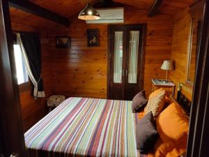 科尔多瓦CABAÑA DE MADERA JUNTO AL LAGO LAS JARAS的小木屋内一间卧室,配有一张床