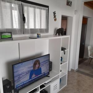 普拉亚布兰卡Villa julima的客厅设有白色架子上的平面电视。