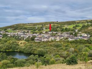 NantlleNorth Wales Cosy Cottage with views near Eryri Snowdonia的山坡上的一个小镇,有红旗