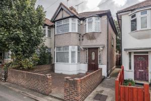 罗姆福特Lovely 4-BedRoom House Near Romford Station的前面有砖墙的房子