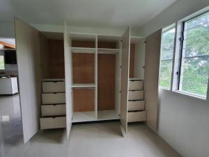 苏瓦Single Room with Shared Kitchen and Living Room的衣柜,带白色架子和窗户