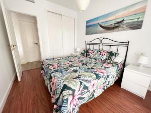 托雷德尔马尔Apartamento Narváez- Altos Del Tomillar的一间卧室配有一张带五颜六色棉被的床