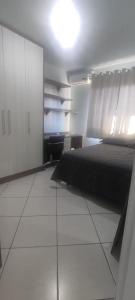 沙佩科Aconchego的一间卧室配有一张黑色的床和白色的橱柜。