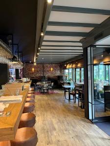 赫鲁斯贝克Hotel De Oude Molen的餐厅设有木桌、椅子和窗户。
