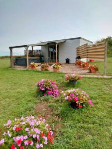 TuxfordBeautiful Wooden tiny house, Glamping cabin with hot tub 3的院子里鲜花的房子