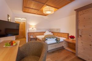 伊施格尔奥林匹亚酒店的一间卧室配有一张床和一张桌子及椅子