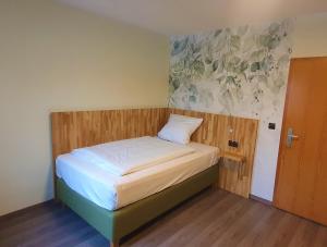 纽伦堡Der Höfener Garten的一间小卧室,配有一张带木制床头板的床