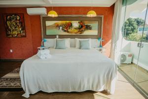 戈亚斯州上帕莱索Villa Terragona的卧室配有白色大床和橙色墙壁