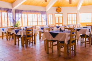 圣佩德罗·德·阿塔卡马埃罗纳托尔拉彻酒店的用餐室设有桌椅和窗户。