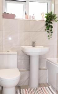 伦敦Hale Lodge的白色的浴室设有水槽和卫生间。