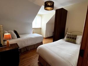 Carterʼs BridgeDrumbar Lodge的酒店客房,设有两张床和一盏灯