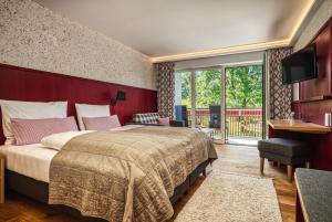 Buchenberg索姆奥乡村酒店的一间卧室配有一张大床和红色床头板