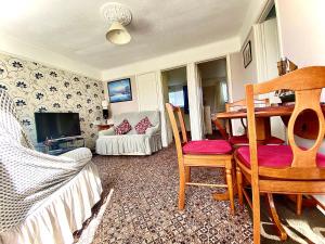 大雅茅斯Quiet and Comfy 2- bedroom Holiday Chalet, walk to the beach, Norfolk的客厅配有桌椅和电视。