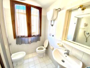 福洛尼卡appartamento Via Siena 1的白色的浴室设有卫生间和水槽。