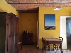 特雷伊索Le camere del Tiglio的一间设有桌子和黄色墙壁的餐厅