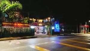 卧佛Forest Paradise Inn Teluk Bahang PRIVATE MALAY TRADITIONAL HOUSE CONCEPT HOTEL的一条空的街道,晚上有灯的建筑