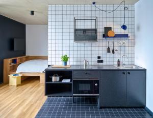 科隆STAYERY Köln Ehrenfeld的一个带水槽的厨房和一张位于客房内的床