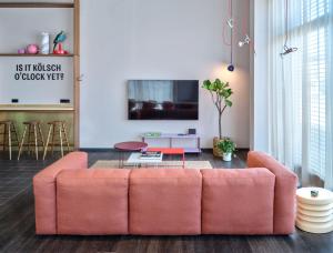 科隆STAYERY Köln Ehrenfeld的客厅配有粉红色的沙发和桌子