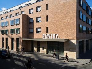 科隆STAYERY Köln Ehrenfeld的建筑的 ⁇ 染,人们在建筑前面行走