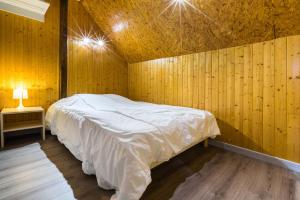 梅特泽拉Chalets de la Wormsa的卧室配有木墙内的一张床
