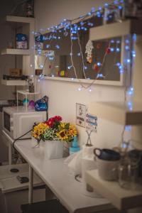 克拉科夫4 Couples & 4 Friends Hostel的厨房柜台上放着鲜花和灯