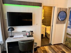 西泰尔斯海灵纳普酒店的一间设有一张桌子的房间,墙上有一台电视机