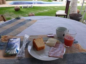 阿奎拉兹Hotel Pousada Summer Way的桌上的面包和一杯果汁