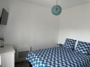 BersonGîte Le petit quartier的一间卧室配有一张带蓝色棉被的床
