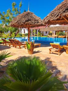 南威Mimi na wewe villa的一个带椅子和遮阳伞的游泳池的度假酒店
