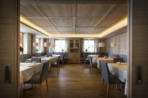 莱赫阿尔贝格Hotel Garni Panorama的一间在房间内配有桌椅的餐厅
