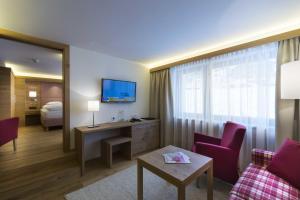 莱赫阿尔贝格Hotel Garni Panorama的酒店客房设有床和客厅。