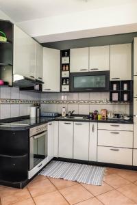 比耶利纳Apartman Jana的厨房配有白色橱柜和黑色家电