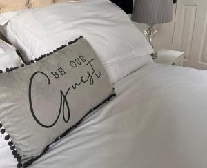 利奇菲尔德Cathedral Apartment的一张带枕头的床,上面写着我们的客人的话