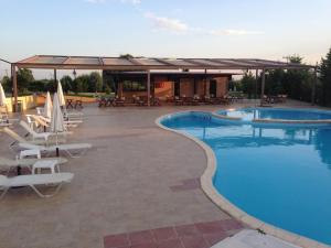 科莫蒂尼阿奇里奥酒店的一个带躺椅的游泳池和一个凉亭