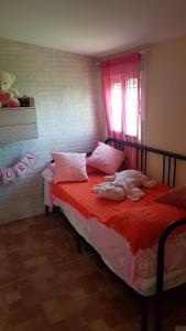 奇皮奥纳Casa Rústica vacacional FILIGRANA en Sanlúcar de Barrameda Zona Montijo的一间卧室配有红色床单和粉红色枕头。