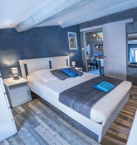 默兹河畔凡尔登Chambre d'hôte et gîte chez Thomas et John的卧室配有带蓝色枕头的大型白色床