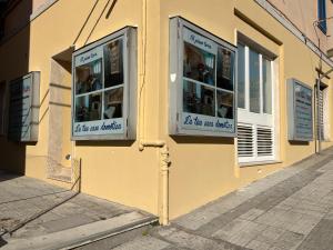 安科纳Al Piano Terra的黄色建筑,街道上有两个窗户
