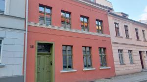托伦Apartamenty K&B Toruń的一条街道上带有绿门的红色建筑